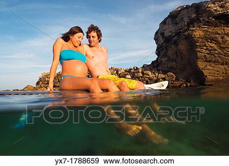 Couple relaxing on a surf board. View Large Photo Image Stock Photo - Couple relaxing on a surf board.. Fotosearch