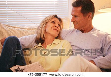 Couple relaxing on couch View Large Photo Image Stock Photo - Couple relaxing on couch. Fotosearch