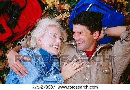 Stock Photo - couple resting on leafy lawn. Fotosearch