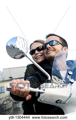 Picture - Couple riding on a motor scooter. Fotosearch