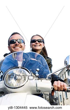Stock Photography - Couple riding on a motor scooter. Fotosearch