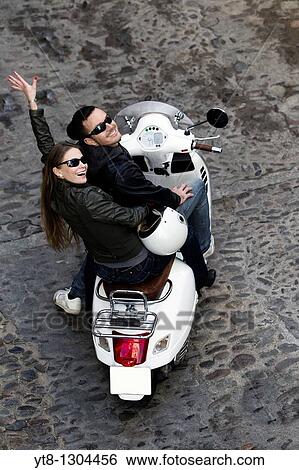 Stock Photograph - Couple riding on a scooter. Fotosearch
