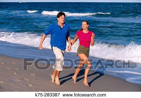 couple running along the beach View Large Photo Image Stock Photo - couple running along the beach. Fotosearch