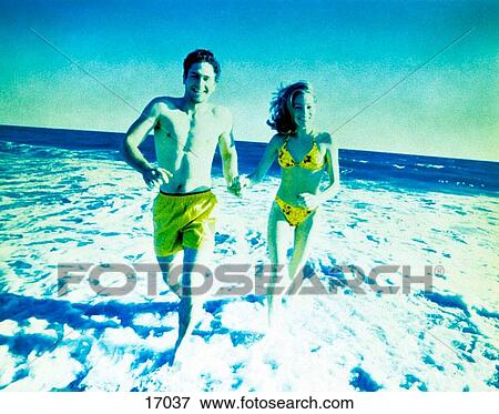 Stock Photo - Couple running on beach. Fotosearch