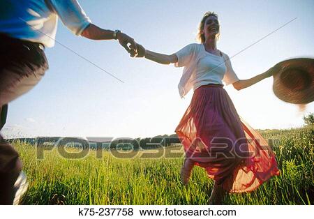 Stock Photo - Couple running through the countryside. Fotosearch