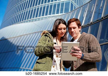 Couple searching on digital tablet in city, digital tablet, Iberdrola Tower, Abandoibarra, Bilbao, Bizkaia, Basque Country, Spain View Large Photo Image Picture - Couple searching on digital tablet in city, digital tablet, Iberdrola Tower, Abandoibarra, Bilbao, Bizkaia, Basque Country, Spain. Fotosearch