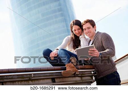 Couple searching on digital tablet in city, digital tablet, Iberdrola Tower, Abandoibarra, Bilbao, Bizkaia, Basque Country, Spain View Large Photo Image Stock Image - Couple searching on digital tablet in city, digital tablet, Iberdrola Tower, Abandoibarra, Bilbao, Bizkaia, Basque Country, Spain. Fotosearch