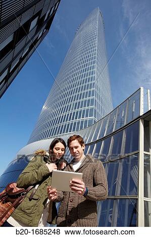 Couple searching on digital tablet in city, digital tablet, Iberdrola Tower, Abandoibarra, Bilbao, Bizkaia, Basque Country, Spain View Large Photo Image Stock Photo - Couple searching on digital tablet in city, digital tablet, Iberdrola Tower, Abandoibarra, Bilbao, Bizkaia, Basque Country, Spain. Fotosearch