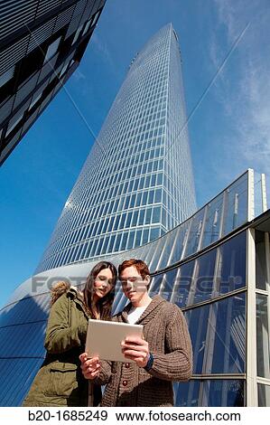 Couple searching on digital tablet in city, digital tablet, Iberdrola Tower, Abandoibarra, Bilbao, Bizkaia, Basque Country, Spain View Large Photo Image Stock Photo - Couple searching on digital tablet in city, digital tablet, Iberdrola Tower, Abandoibarra, Bilbao, Bizkaia, Basque Country, Spain. Fotosearch