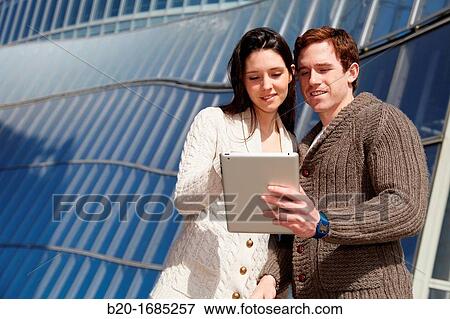 Couple searching on digital tablet in city, digital tablet, Iberdrola Tower, Abandoibarra, Bilbao, Bizkaia, Basque Country, Spain View Large Photo Image Stock Photo - Couple searching on digital tablet in city, digital tablet, Iberdrola Tower, Abandoibarra, Bilbao, Bizkaia, Basque Country, Spain. Fotosearch