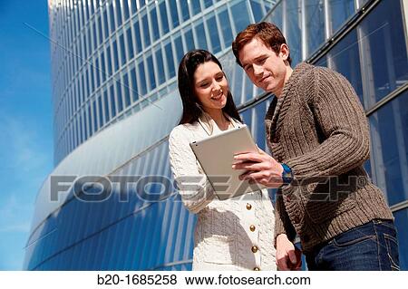 Couple searching on digital tablet in city, digital tablet, Iberdrola Tower, Abandoibarra, Bilbao, Bizkaia, Basque Country, Spain View Large Photo Image Stock Photo - Couple searching on digital tablet in city, digital tablet, Iberdrola Tower, Abandoibarra, Bilbao, Bizkaia, Basque Country, Spain. Fotosearch