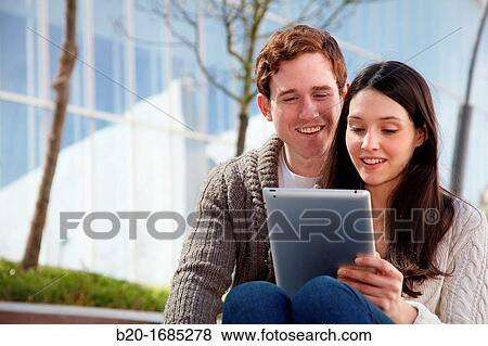 Couple searching on digital tablet in city, digital tablet, Iberdrola Tower, Abandoibarra, Bilbao, Bizkaia, Basque Country, Spain View Large Photo Image Stock Photo - Couple searching on digital tablet in city, digital tablet, Iberdrola Tower, Abandoibarra, Bilbao, Bizkaia, Basque Country, Spain. Fotosearch
