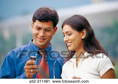 Couple seeing SMS message on mobile and smiling. View Large Photo Image Stock Image - Couple seeing SMS message on mobile and smiling.. Fotosearch
