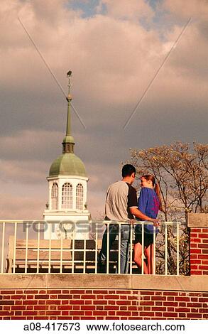Couple shares a private moment with spire of library in background View Large Photo Image Stock Image - Couple shares a private moment with spire of library in background. Fotosearch
