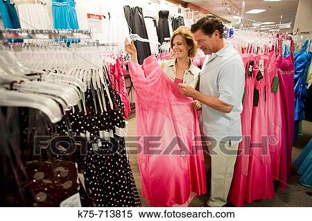 Stock Photography - couple shopping for woman's formal wear. Fotosearch