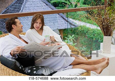 couple sitting and reading newspaper on sofa View Large Photo Image Stock Photo - couple sitting and reading newspaper on sofa. Fotosearch