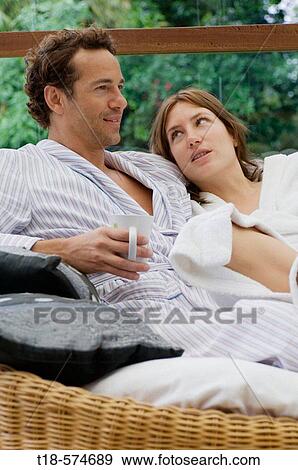 couple sitting and relxing on sofa View Large Photo Image Stock Photo - couple sitting and relxing on sofa. Fotosearch