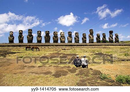 Stock Photography - Couple sitting at Ahu Tongariki Moai - Easter Island, Chile. Fotosearch