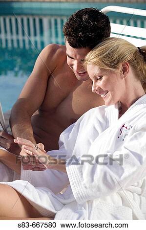 Couple sitting by pool. Woman admiring here engagement ring. View Large Photo Image Stock Image - Couple sitting by pool. Woman admiring here engagement ring.. Fotosearch