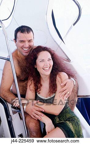 Stock Photo - Couple sitting inside yatch. Fotosearch