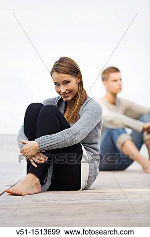 Couple sitting on a pier in Wansee, Berlin View Large Photo Image Stock Photo - Couple sitting on a pier in Wansee, Berlin. Fotosearch