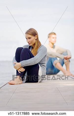 Stock Photography - Couple sitting on a pier in Wansee, Berlin. Fotosearch