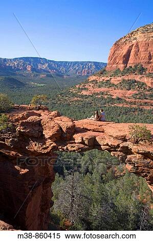 Couple sitting on arch Sedona, Arizona View Large Photo Image Stock Photography - Couple sitting on arch Sedona, Arizona. Fotosearch