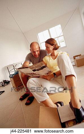 Couple sitting on chair and boxes, looking at paint chart in their new house View Large Photo Image Stock Image - Couple sitting on chair and boxes, looking at paint chart in their new house. Fotosearch