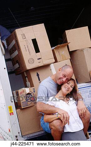 Couple sitting on moving truck deck View Large Photo Image Stock Image - Couple sitting on moving truck deck. Fotosearch