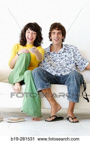 Couple sitting on the sofa at home View Large Photo Image Stock Image - Couple sitting on the sofa at home. Fotosearch