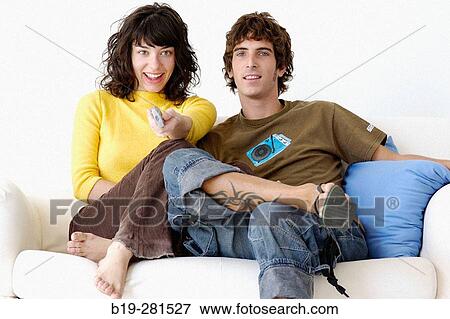 Couple sitting on the sofa at home View Large Photo Image Stock Photo - Couple sitting on the sofa at home. Fotosearch