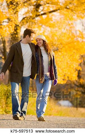 Couple smiling and walking country road View Large Photo Image Stock Image - Couple smiling and walking country road. Fotosearch