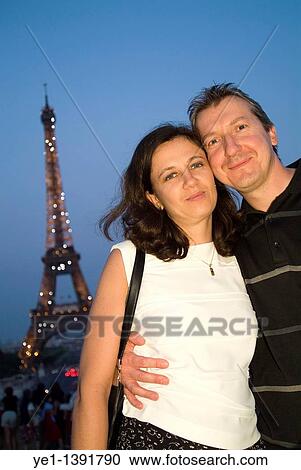 Couple smiling in front of Eiffel Tower at dusk, Paris, France View Large Photo Image Stock Image - Couple smiling in front of Eiffel Tower at dusk, Paris, France. Fotosearch
