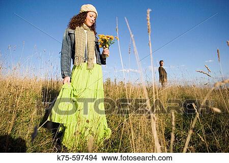 Couple standing apart in field View Large Photo Image Picture - Couple standing apart in field. Fotosearch