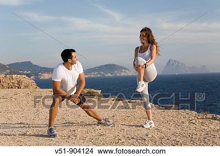 Couple stretching in a cliff by the sea in Ibiza View Large Photo Image Picture - Couple stretching in a cliff by the sea in Ibiza. Fotosearch