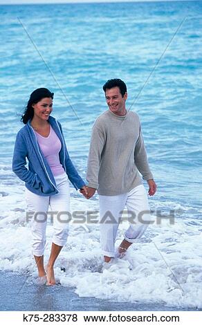 couple strolling along shoreline View Large Photo Image Stock Photo - couple strolling along shoreline. Fotosearch