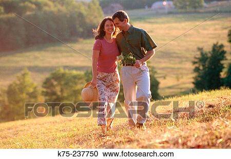 Couple strolling on a summer day in the country View Large Photo Image Stock Image - Couple strolling on a summer day in the country. Fotosearch