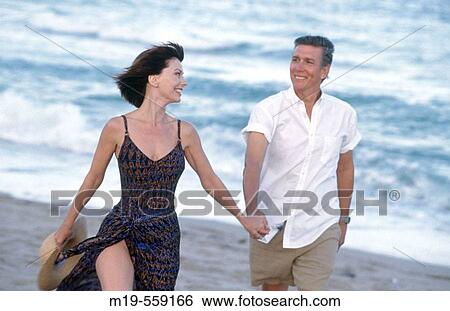 couple strolling on the beach View Large Photo Image Stock Photograph - couple strolling on the beach. Fotosearch