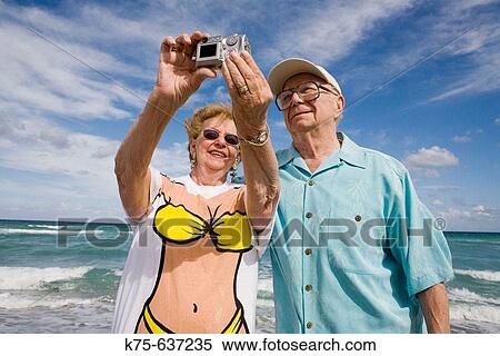 Stock Photography - Couple taking a photo with digital camera. Fotosearch