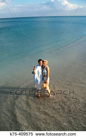 Couple taking self-portrait with camera phone at the beach View Large Photo Image Stock Photography - Couple taking self-portrait with camera phone at the beach. Fotosearch