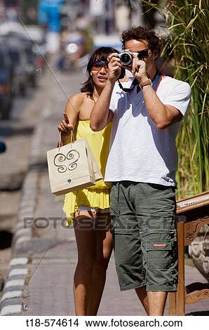 couple taking snapshot on sidewalk View Large Photo Image Picture - couple taking snapshot on sidewalk. Fotosearch