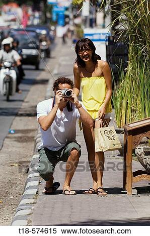couple taking snapshot on sidewalk View Large Photo Image Stock Photography - couple taking snapshot on sidewalk. Fotosearch