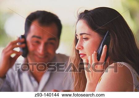 Picture - Couple talking on cell phones. Fotosearch