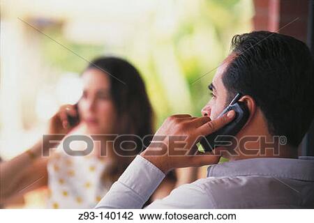 Stock Image - Couple talking on cell phones. Fotosearch