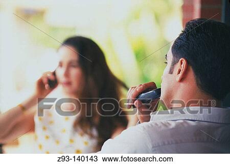 Stock Image - Couple talking on cell phones. Fotosearch