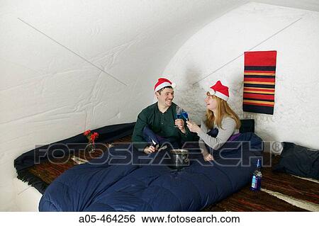 Couple toasting in a room of the igloo hotel with Father Christmas hats. Hotel Kakslauttanen. Lapland. Ivalo. Finlandia View Large Photo Image Stock Photograph - Couple toasting in a room of the igloo hotel with Father Christmas hats. Hotel Kakslauttanen. Lapland. Ivalo. Finlandia. Fotosearch