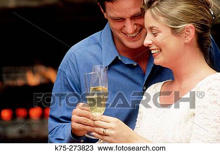 Couple toasting in front of fireplace View Large Photo Image Stock Image - Couple toasting in front of fireplace. Fotosearch