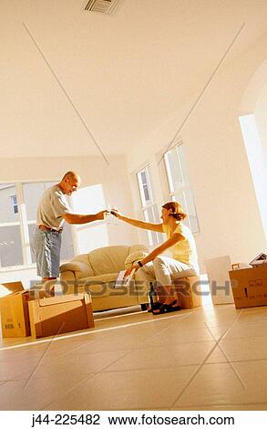 Couple toasting with glass of wine in their new house View Large Photo Image Stock Image - Couple toasting with glass of wine in their new house. Fotosearch