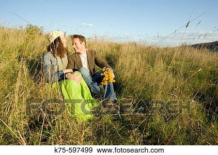 Couple together on hilltop in field View Large Photo Image Stock Photo - Couple together on hilltop in field. Fotosearch