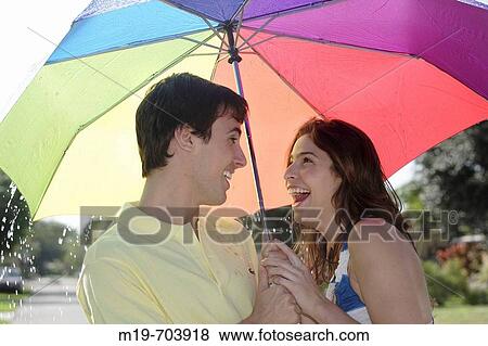 Couple under an umbrella in the rain View Large Photo Image Stock Photo - Couple under an umbrella in the rain. Fotosearch